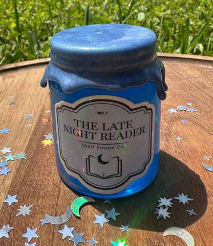 Blue jar labeled 'The Late Night Reader' on a wooden surface with decorative stars.